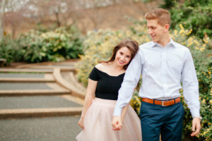 A couple walks hand in hand at Meridian Hill Park in DC. The girl wears a pink tulle skirt and the guy a blue button-up