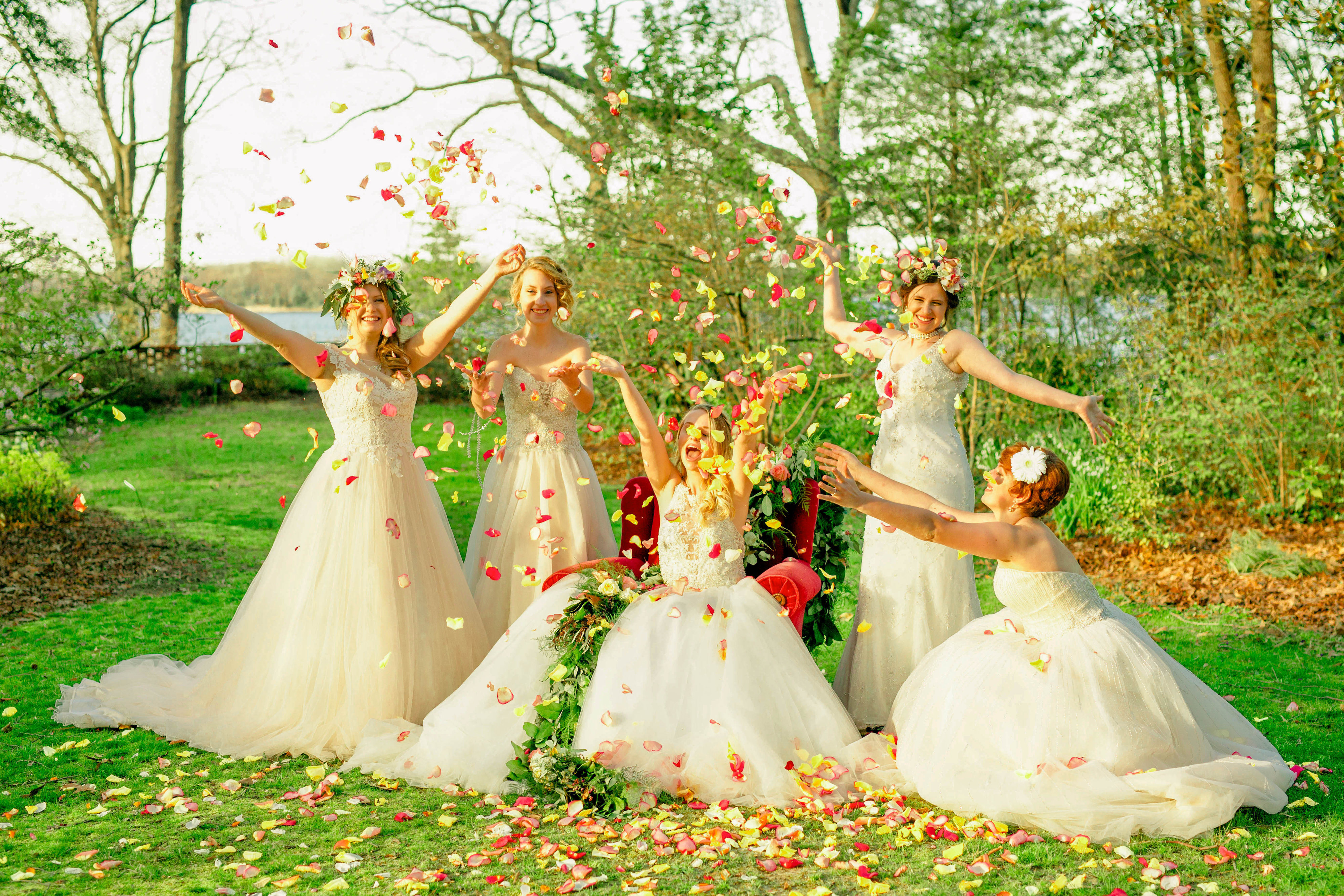 Bridal portraits in a garden with 5 girls throwing rose petals