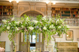 The bountiful arch made of greenery and flowers over the table at the George Peabody Library in Baltimore, MD