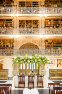 The styled table sits inside the George Peabody Library in Baltimore, MD surrounded by rows and rows of books