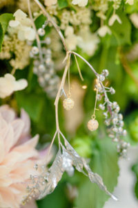A detailed look at the floral backdrop with earrings hanging from a silver branch in the George Peabody Library in Baltimore, MD
