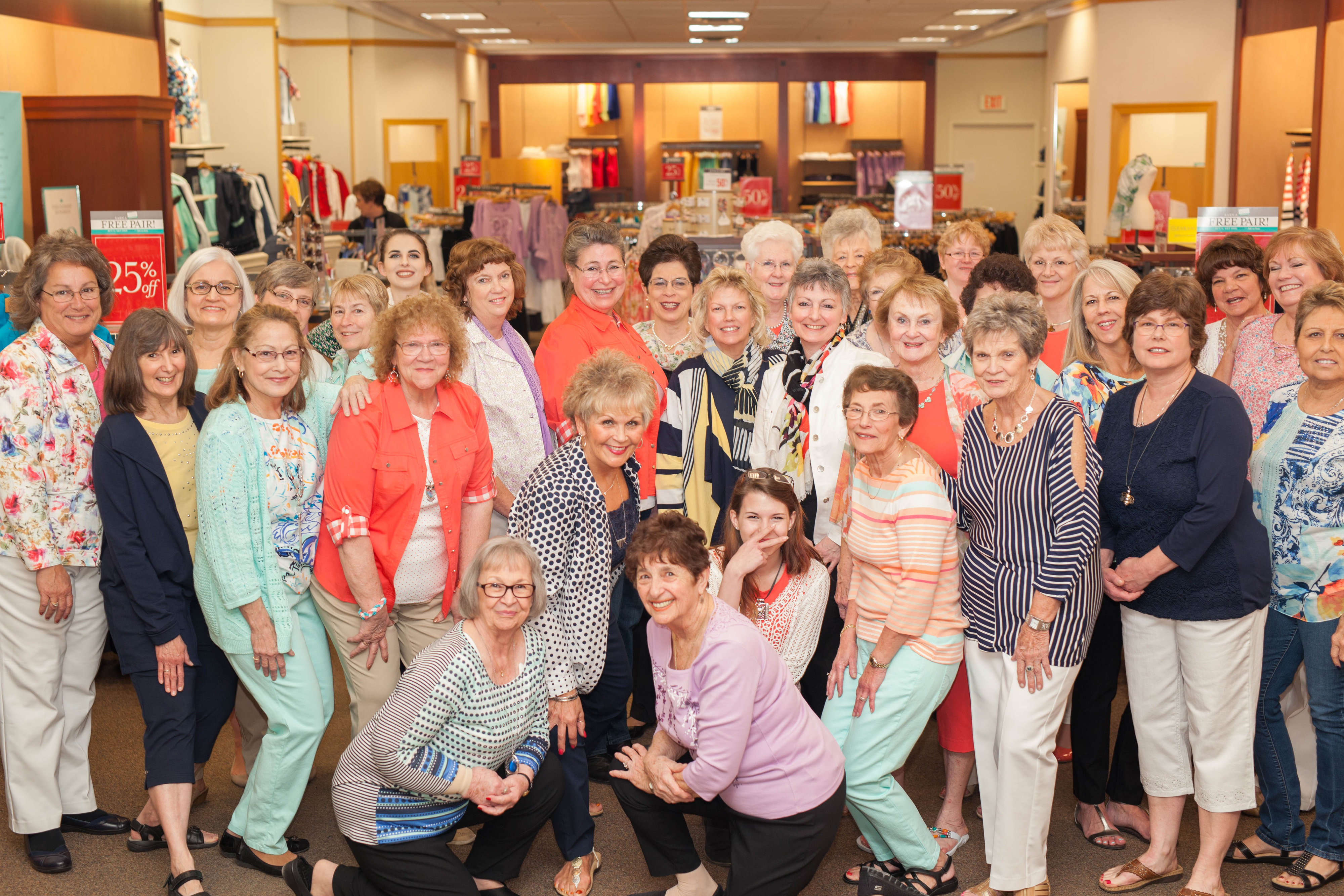 A group of ladies posing for a photo in a clothing store