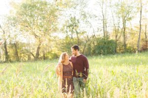 A September backyard anniversary session in Woodsboro MD. A couple walks together under the golden glow of the sun
