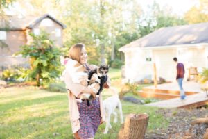 A September backyard anniversary session in Woodsboro MD. A girl carries her many cats smiling