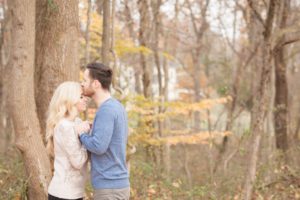 Cozy Autumn Engagement Session at Rockburn Branch Park in Elkridge, MD. A loving couple stands with the fall foliage in a private moment