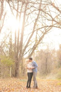 Cozy Autumn Engagement Session at Rockburn Branch Park in Elkridge, MD. A loving couple stands under the glowing sun kissing