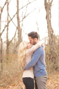 Cozy Autumn Engagement Session at Rockburn Branch Park in Elkridge, MD. A loving couple stands under the dreamy sun in an emotional embrace and almost kiss