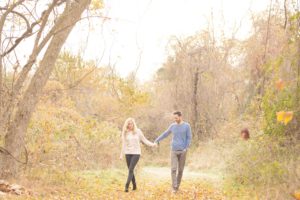Cozy Autumn Engagement Session at Rockburn Branch Park in Elkridge, MD. A loving couple walks under the dreamy glow of the sunrise