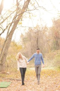 Cozy Autumn Engagement Session at Rockburn Branch Park in Elkridge, MD. A loving couple walks under the dreamy glow of the sunrise
