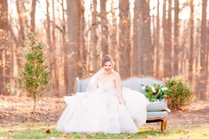 A young bride sits on a chaise lounge laughing at the Liriodendron Mansion in Bel Air Maryland for her winter wedding