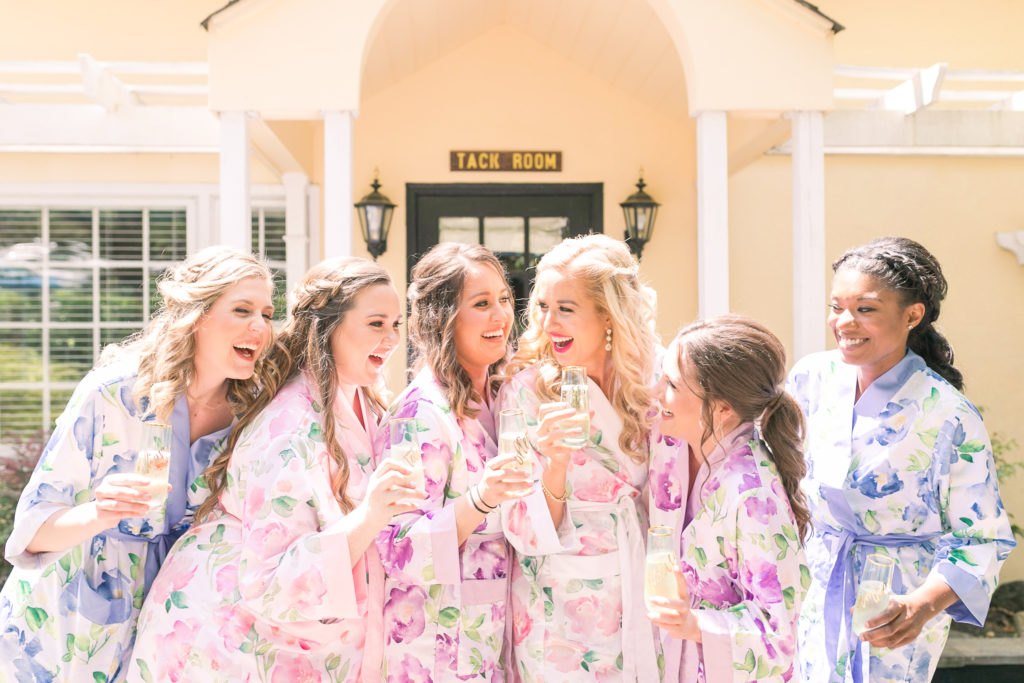 Bride and Bridesmaids toasting in floral robes in a summer garden wedding in Airlie Virginia