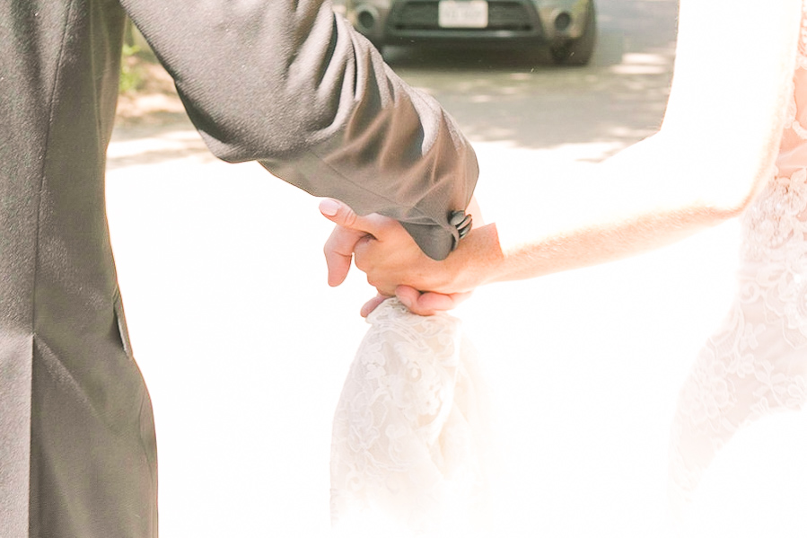 Brie and Groom hold hands for a summer garden wedding Airlie in Warrenton Virginia