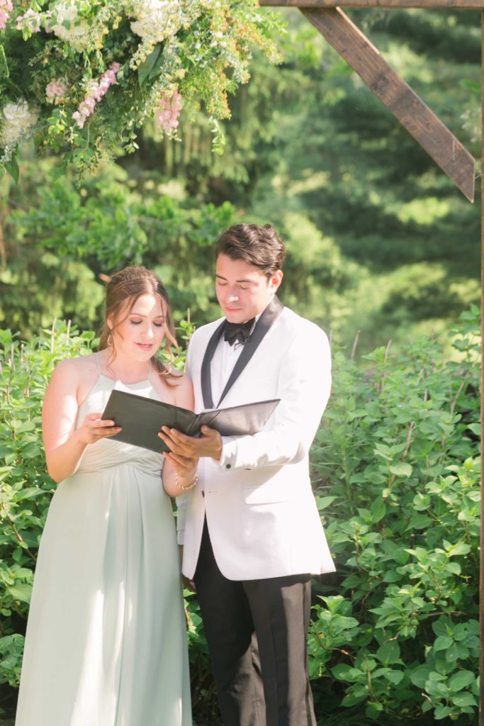 A bridesmaid reads a poem in a summer garden wedding Airlie in Warrenton Virginia