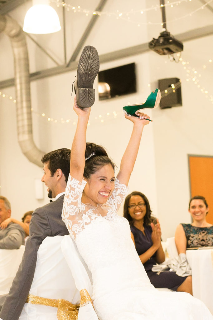 bride and groom play the shoe game in a summer Frederick Maryland Wedding Reception at Brunswick FireHall