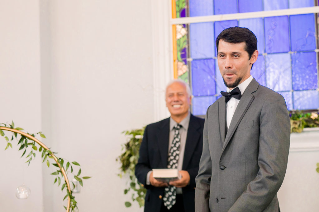 The groom watches emotionally as his bride come down the aisle for a latino wedding in the summer in frederick maryland wedding at the Seventh Day Adventist Church