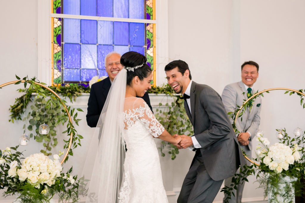 The Bride and Groom laugh at their ceremony in a latino wedding in the summer in frederick maryland wedding at the Seventh Day Adventist Church