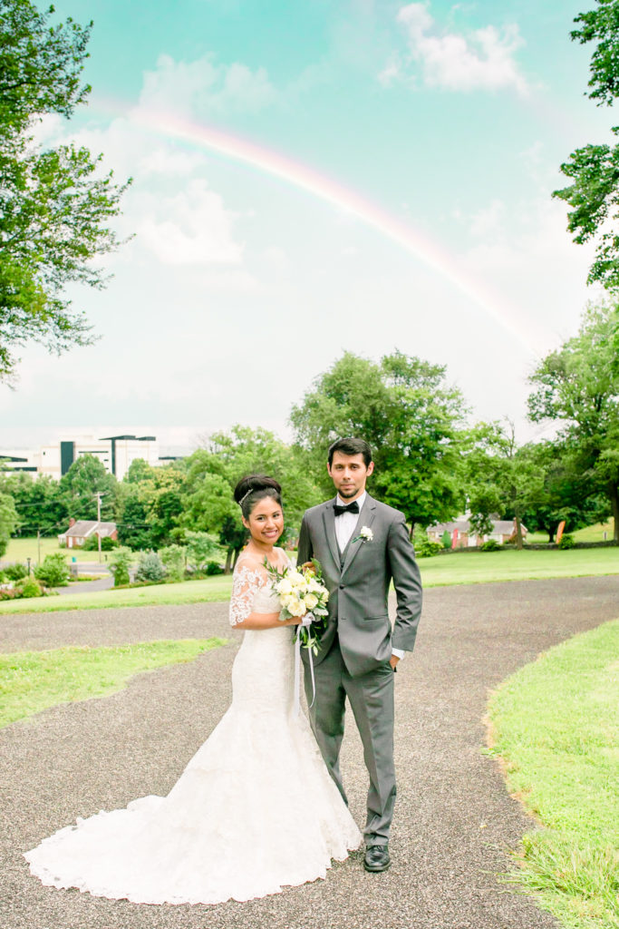 The Bride and Groom stand underneath a rainbow smiling together in a summer Frederick Maryland Wedding at Prospect Hall Mansion 