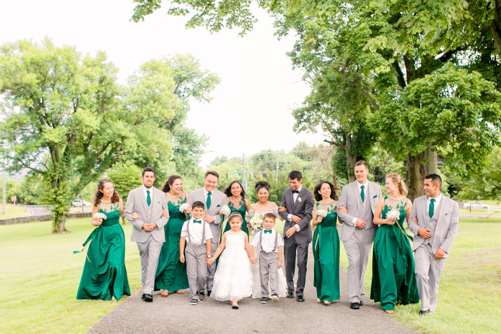 Bride and Groom walk together with Bridal Party in emerald green dresses and ties in a summer Frederick Maryland Wedding at Prospect Hall Mansion 