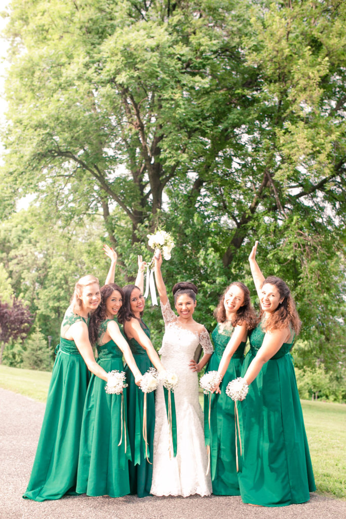 Bride and bridesmaids pose celebrating in emerald green dresses in a summer Frederick Maryland Wedding at Prospect Hall Mansion 