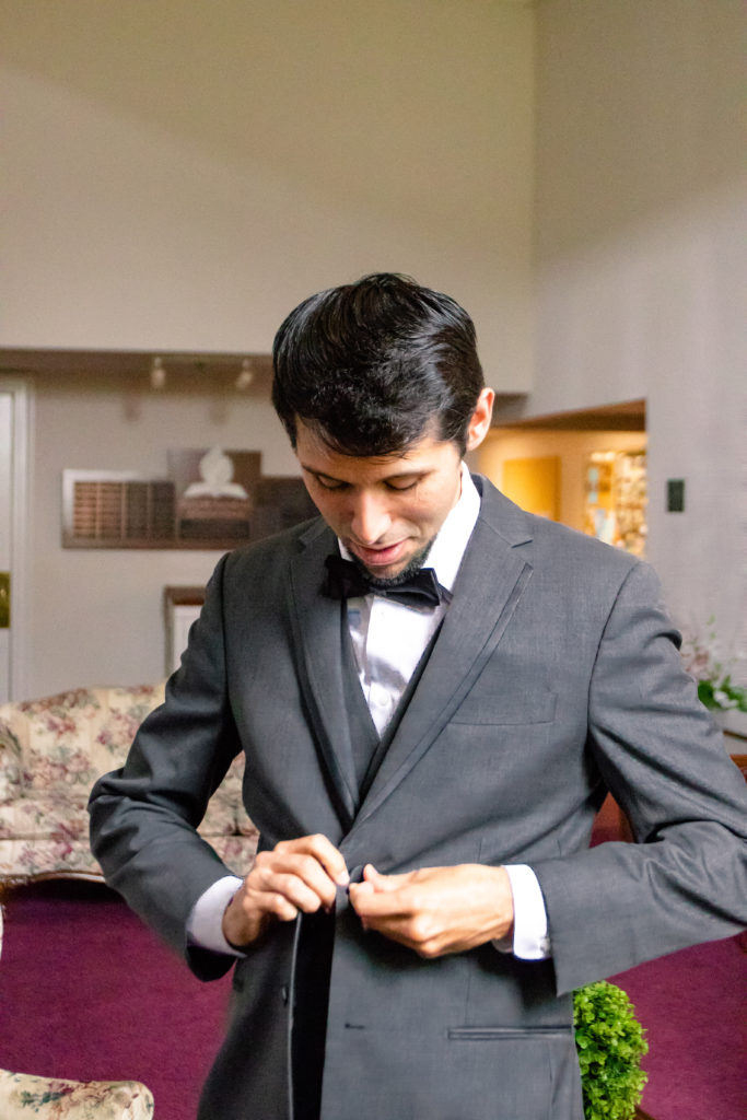 groom buttoning up his jacket in a summer Frederick Maryland Wedding