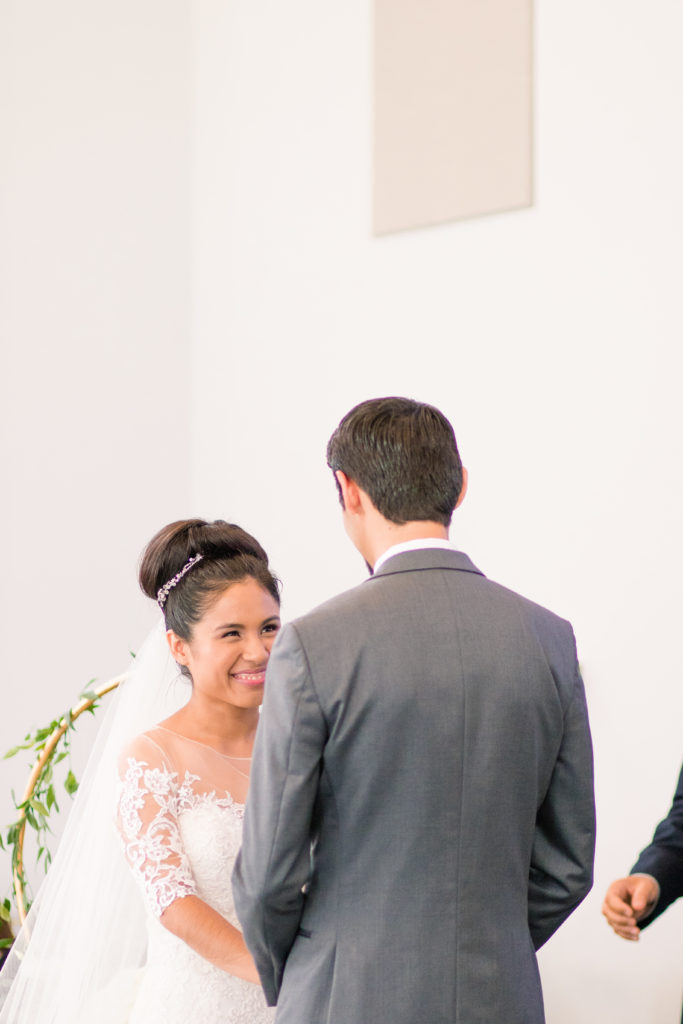 the bride smiles up at her groom in a latino wedding in the summer in frederick maryland wedding at the Seventh Day Adventist Church