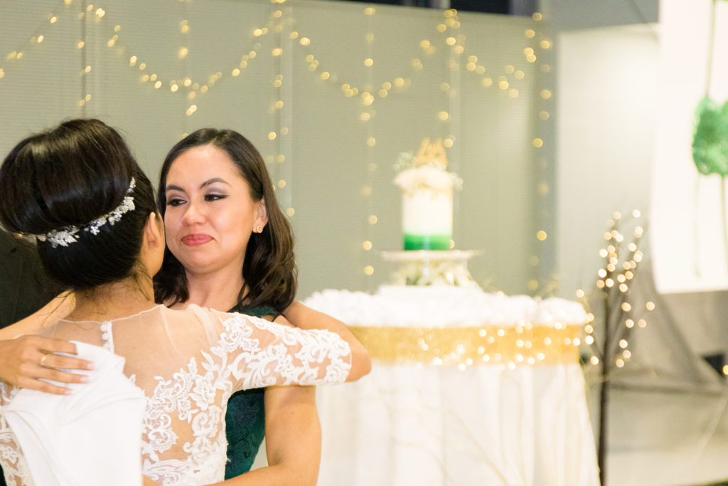 Bride embraces Maid of Honor at a summer Frederick Maryland Wedding Reception at Brunswick FireHall