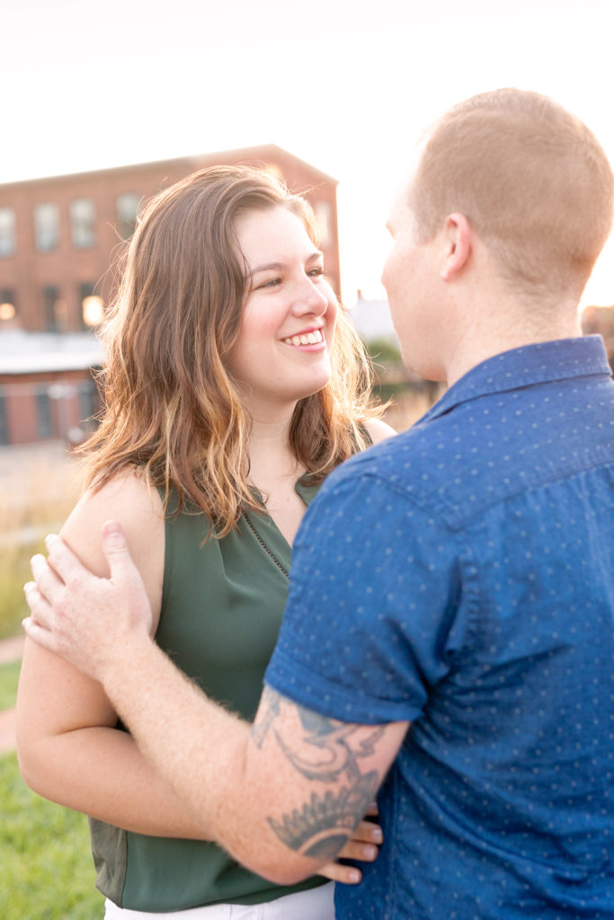 downtown Frederick sunrise summer engagement session with a couple smiling at each other