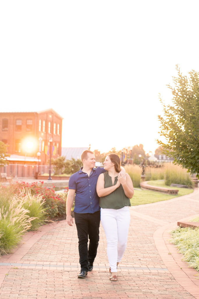 downtown Frederick sunrise summer engagement session with a couple walking together smiling