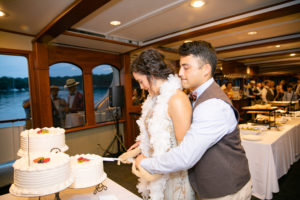 Yacht Wedding in Annapolis Maryland in August for a 1920's themed wedding. Bride and groom cutting wedding cake