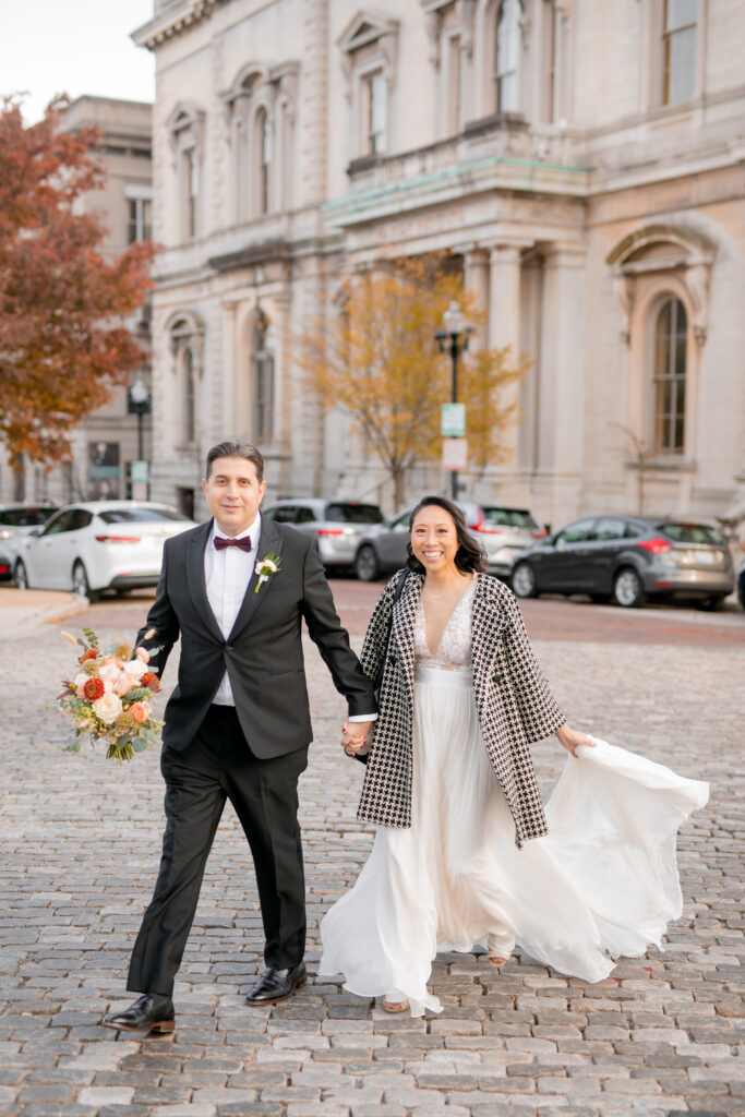 A bride and groom walk around Mount Vernon at at the Peabody Library with Maryland Wedding Photographer