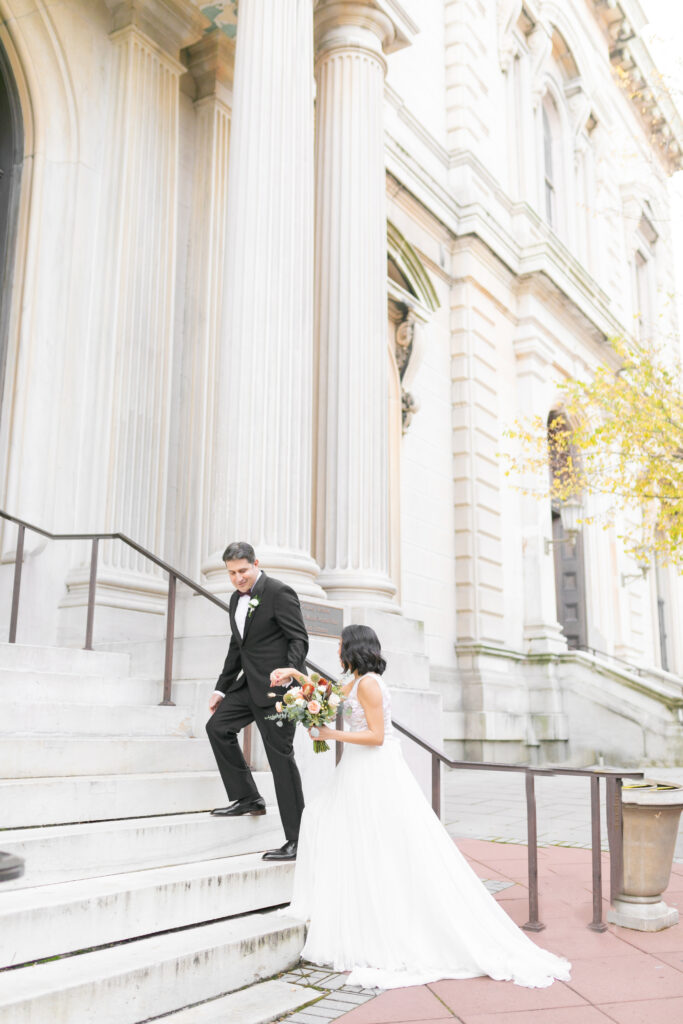 A bride and groom take a portrait at the Peabody Library with Maryland Wedding Photographer