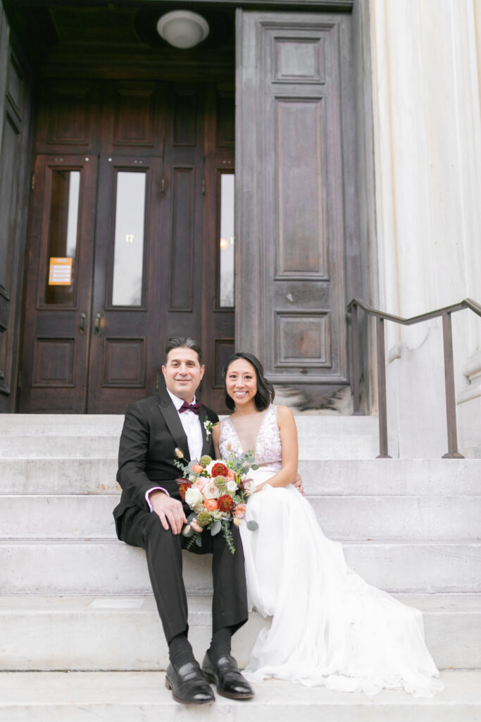 A bride and groom take a portrait at the Peabody Library with Maryland Wedding Photographer