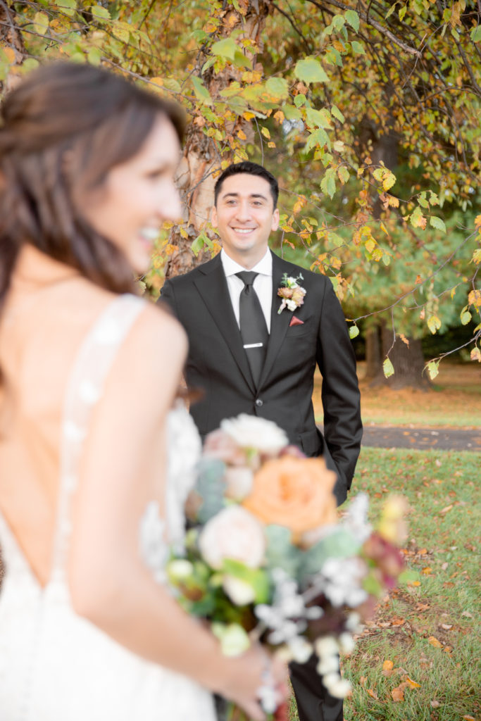 Maryland Wedding Photographer snaps a photo as a groom looks on at his bride at Big Cork Vineyards
