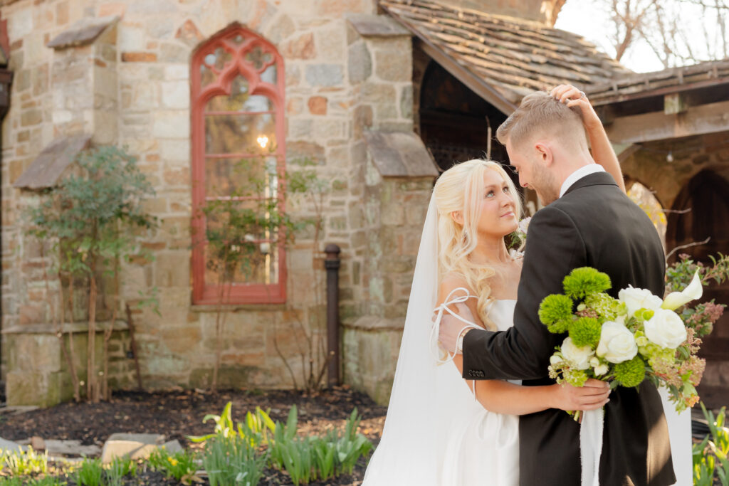 A tender moment between a bride and groom during their portraits at the Cloisters Castle is photographed by Maryland Wedding Photographer