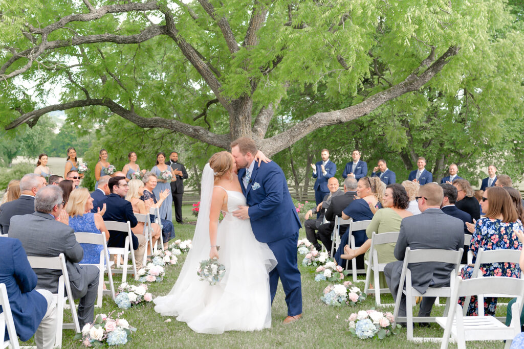 A bride and groom share their first kiss at their ceremony at Walker's Overlook for Maryland Wedding Photographer